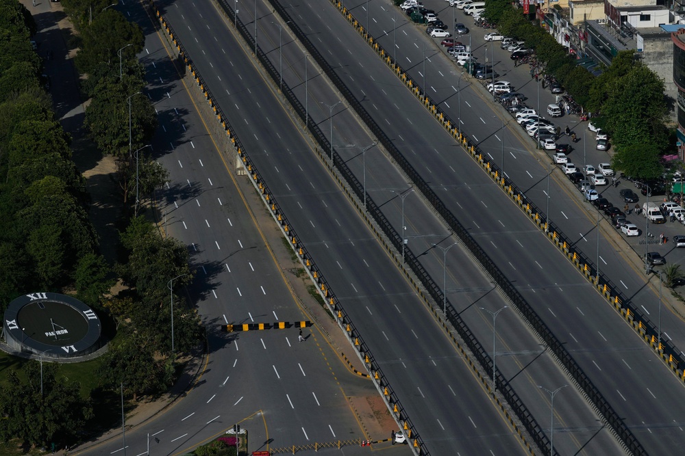 A man crosses a deserted road barricaded by authorities due to security arrangements for the US and Iran talks, in Islamabad, Pakistan, Wednesday, 22 April 2026 (AP)