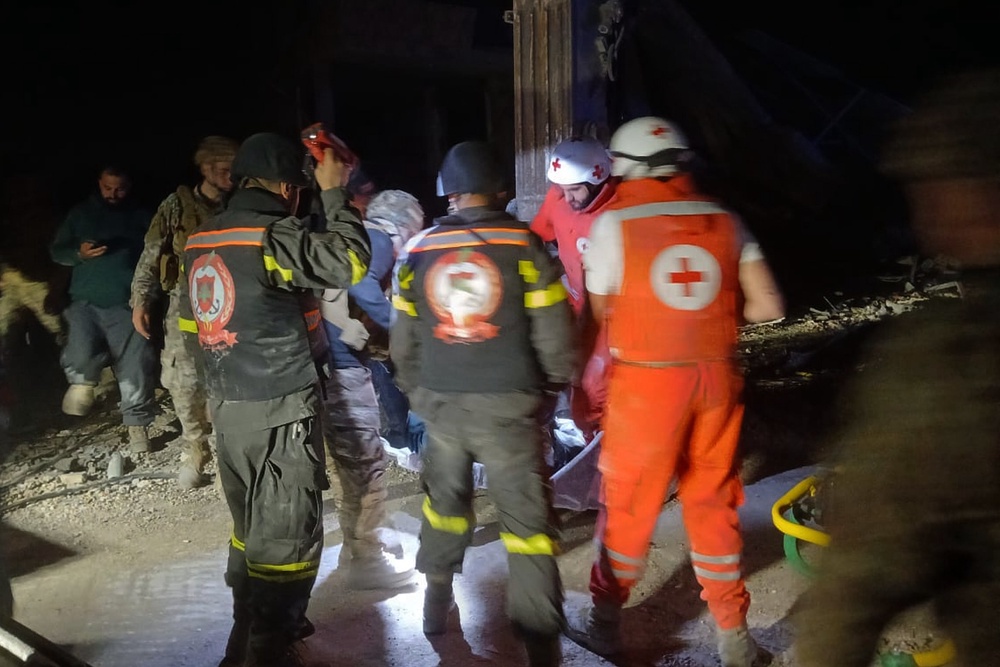 This photo released by the Lebanese Civil Defense, show Lebanese Red Cross volunteers and Civil Defense workers carrying the body of the Lebanese journalist Amal Khalil. (AP)