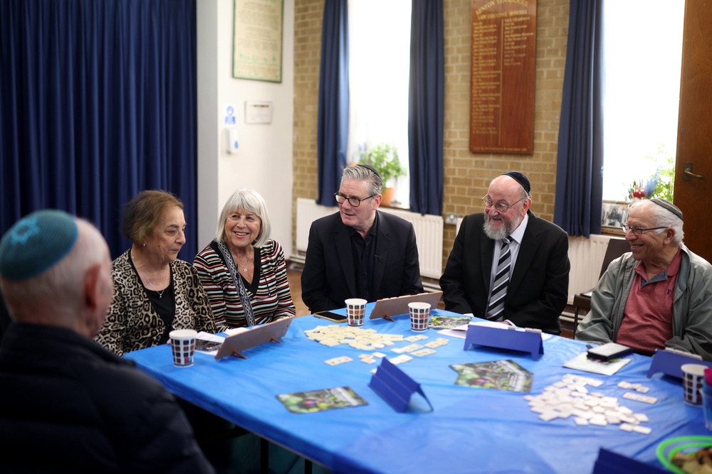Sir Keir Starmer speaks as Chief Rabbi Ephraim Mirvis (2nd right) reacts while they join people during a visit Kenton United Synagogue (Getty)