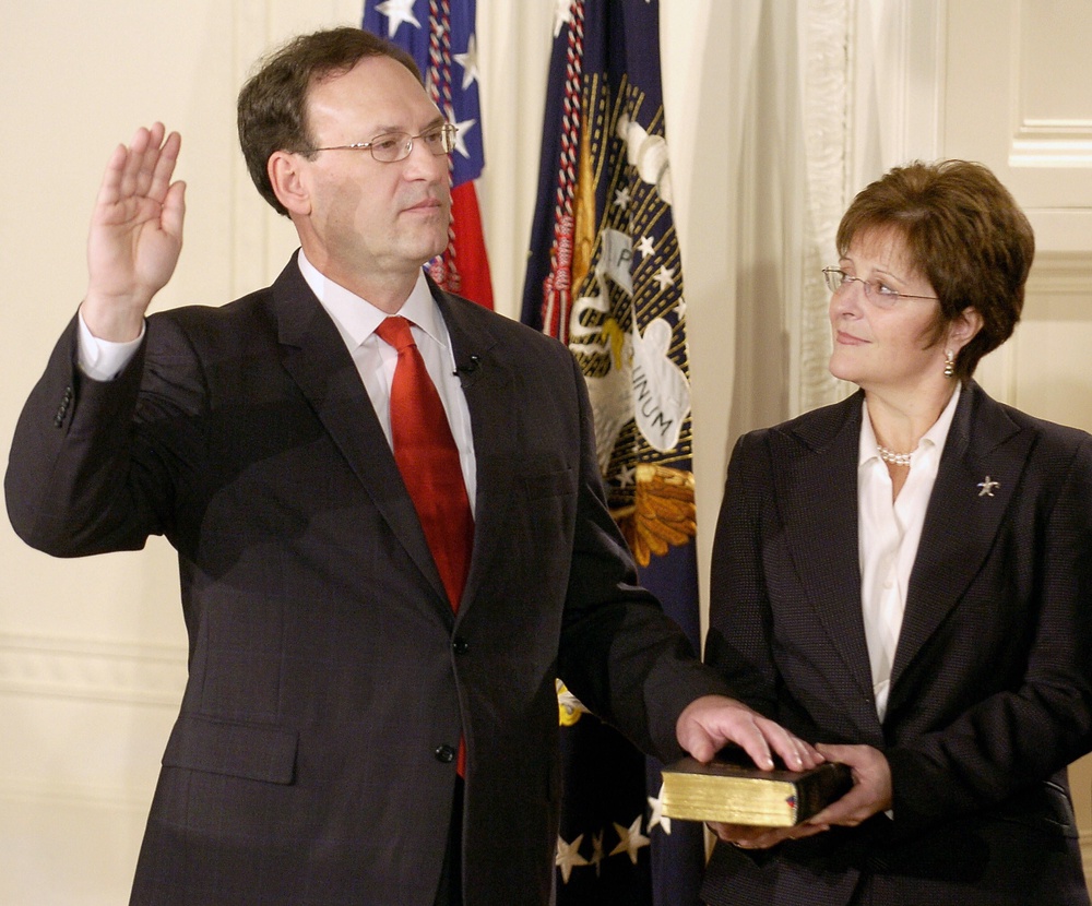 Supreme Court Justice Samuel Alito raises his right hand as he participates in a ceremonial swearing-in in the East Room of the White House in Washington 01 February 2006 as his wife Martha-Ann holds the Bible (AFP/Getty)