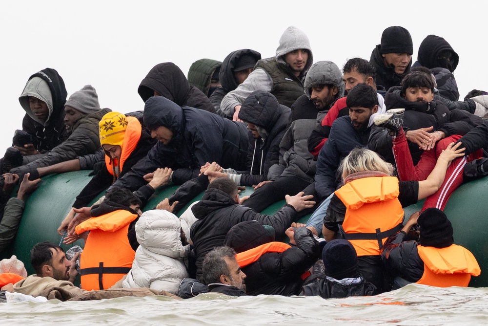 Migrants board a dinghy before attempting to sail into the English Channel earlier this month (Getty)