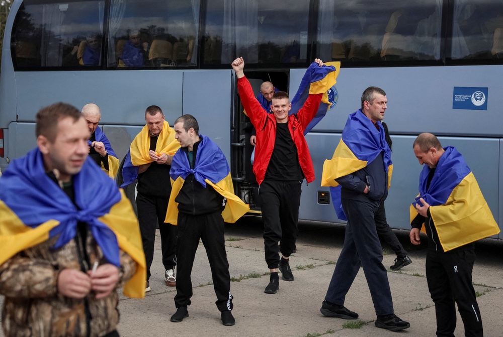 Ukrainian prisoners of war (POWs) react after a swap, amid Russia's attack on Ukraine, at an unknown location in Ukraine (Reuters)
