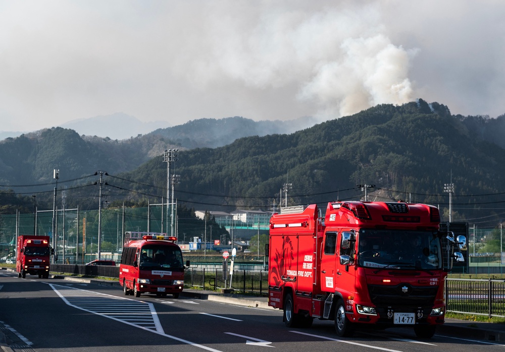 Fire trucks move to a new location as smoke is seen in the background in the town of Otsuchi in Iwate Prefecture (AFP/Getty)