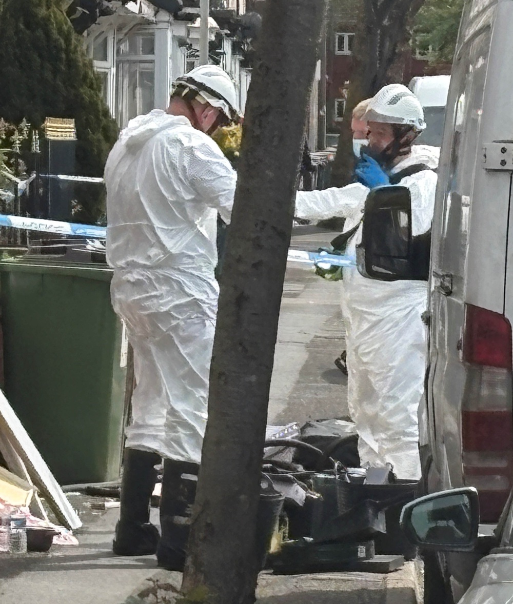 Investigators wearing protective clothing were seen combing the property on Saturday (PA)