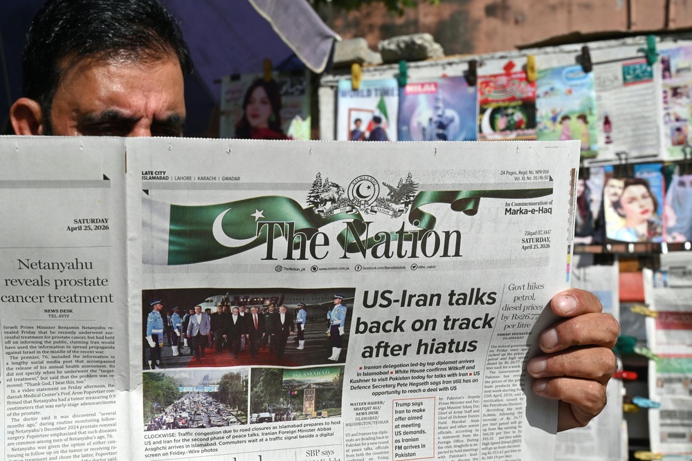 A man reads a newspaper at a roadside stall in Islamabad on April 25, 2026 (AFP/Getty)