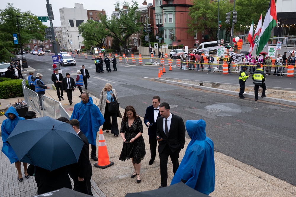 Protestors stood behind a partition, holding signs and flags as guests entered the hotel (Getty Images)