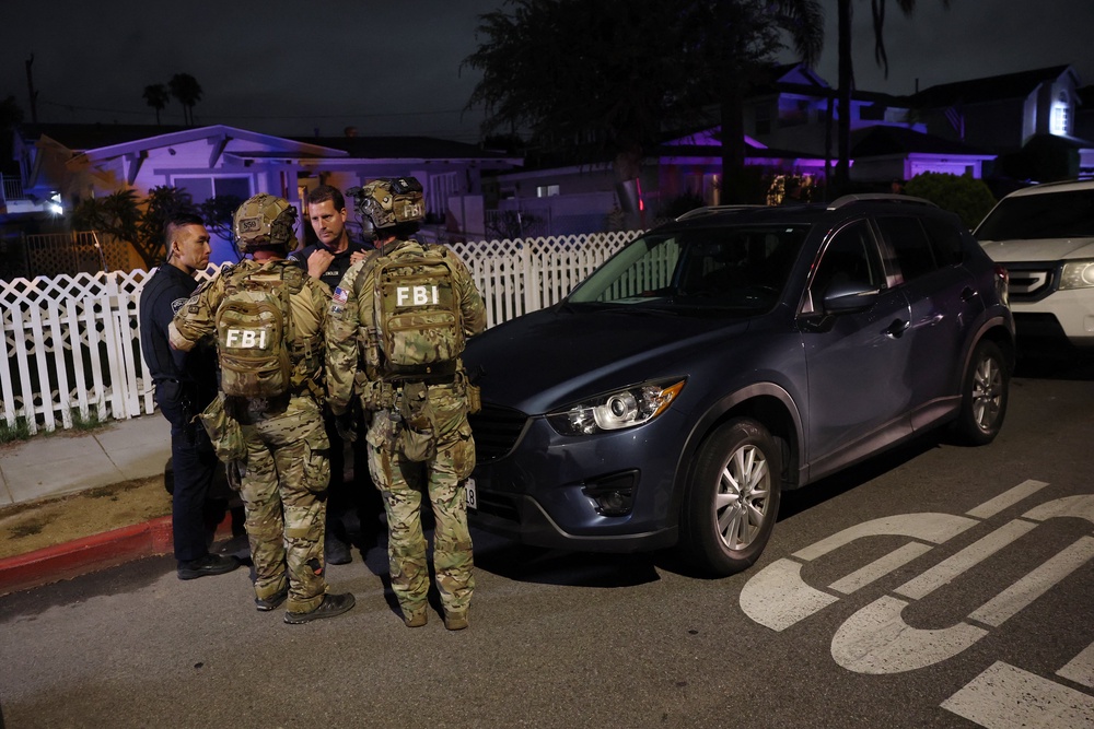 FBI tactical agents talk to Torrance police officers at the investigation scene (AFP/Getty)