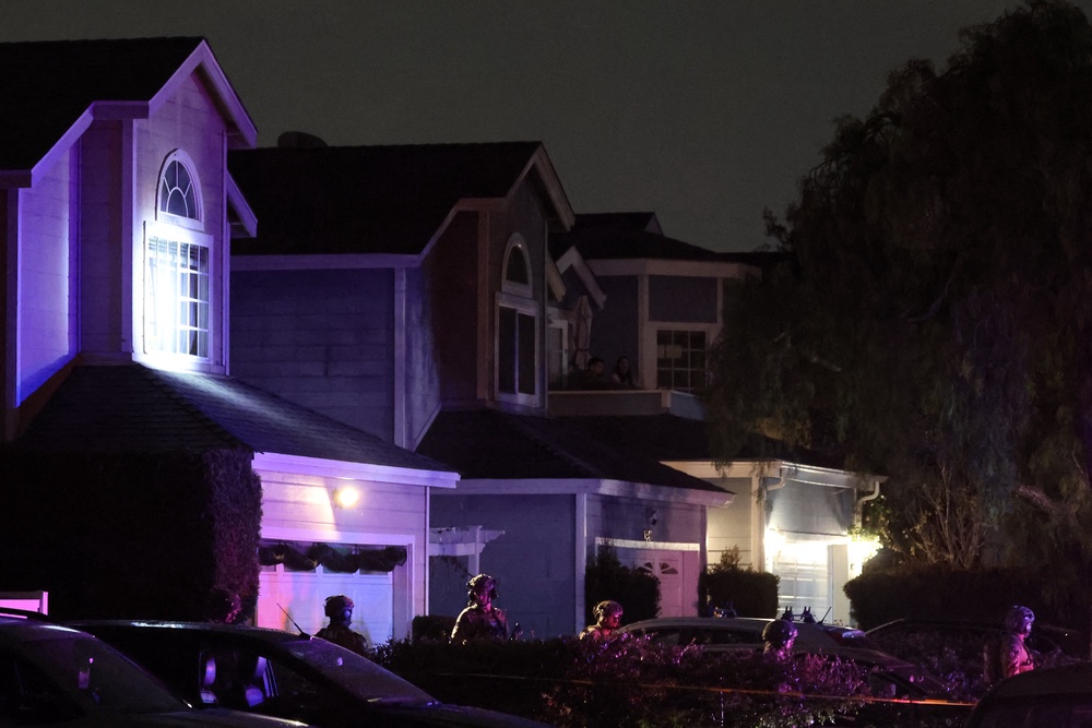 FBI tactical agents walk as they prepare to leave the investigation scene near a residence believed to be linked to Cole Allen (AFP/Getty)