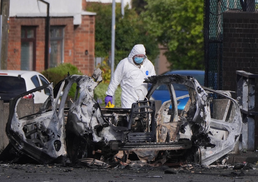 Forensic investigators at the scene in Dunmurry in Northern Ireland after reports of a car explosion outside a police station (Niall Carson/PA) (PA Wire)