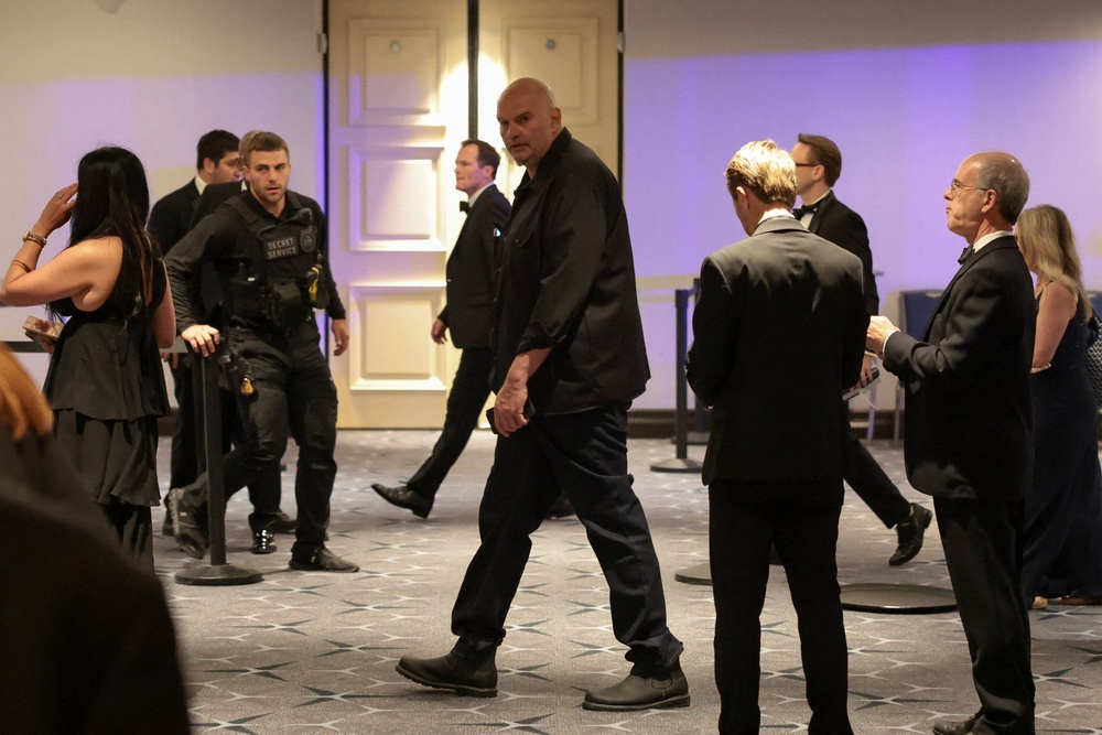 Sen. John Fetterman (D-PA) is escorted through the lobby following the shooting at the annual White House Correspondents’ Association dinner Saturday night (Reuters)