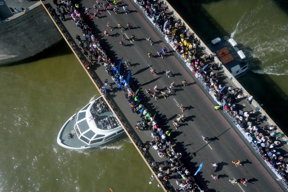 A boat passes under Tower Bridge as crowds line the race route (Jonathan Brady/PA) (PA Wire)