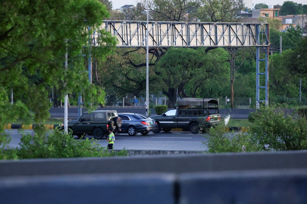 A police officer stands guard as a motorcade reportedly carrying Abbas Araghchi passes by in Islamabad (Reuters)