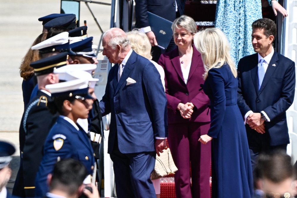 Britain's King Charles III (C-L) and Britain's Queen Camilla (hidden) are greeted as they step off their plane upon arrival at Joint Base Andrews, Maryland, on April 27, 2026. (AFP/Getty)