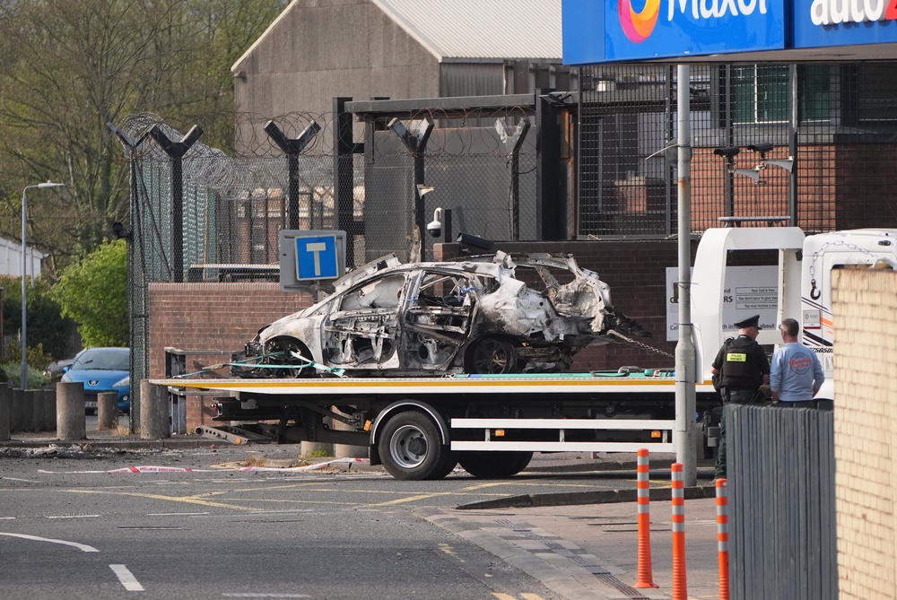 The remains of an exploded vehicle are removed from the scene (Niall Carson/PA) (PA Wire)