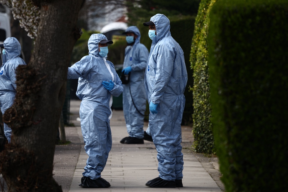 Police forensic officers work outside a house in a street near an incident where volunteer ambulances run by a Jewish organisation were set on fire on 23 March (AFP/Getty)