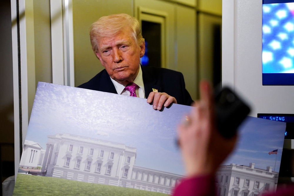 Trump shows reporters a rendering of the ballroom while speaking aboard Air Force One earlier this month (Reuters)