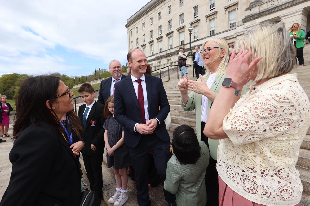 Communities minister Gordon Lyons (centre) with campaigners from the deaf community outside the Parliament Buildings at Stormont (Liam McBurney/PA) (PA Wire)