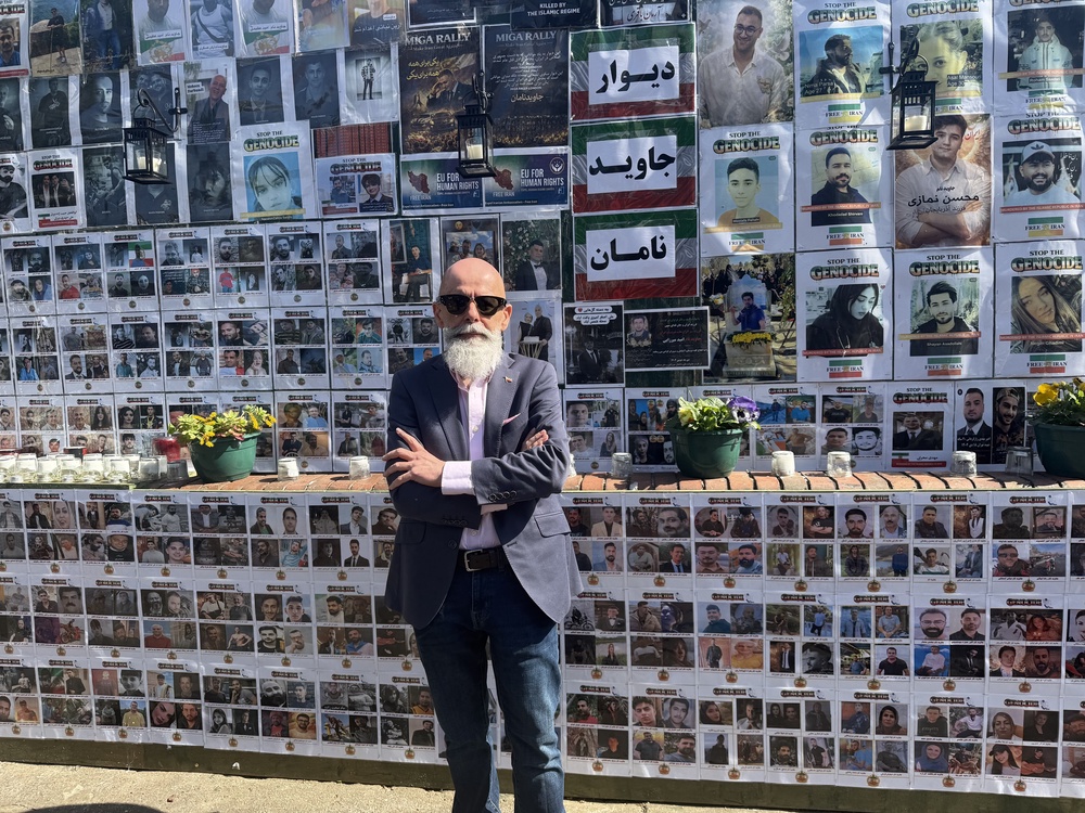 Ahad Ghanbary, an Iranian community advocate, beside the memorial wall (Blaise Cloran/PA) (PA Wire)