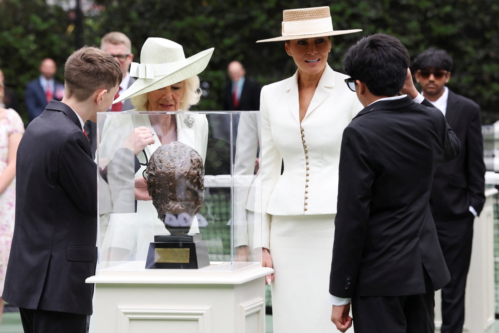 The Queen and Mrs Trump with American students who were using virtual reality headsets and AI-enabled glasses to view artefacts from the White House (Suzanne Plunkett/PA) (PA Wire)