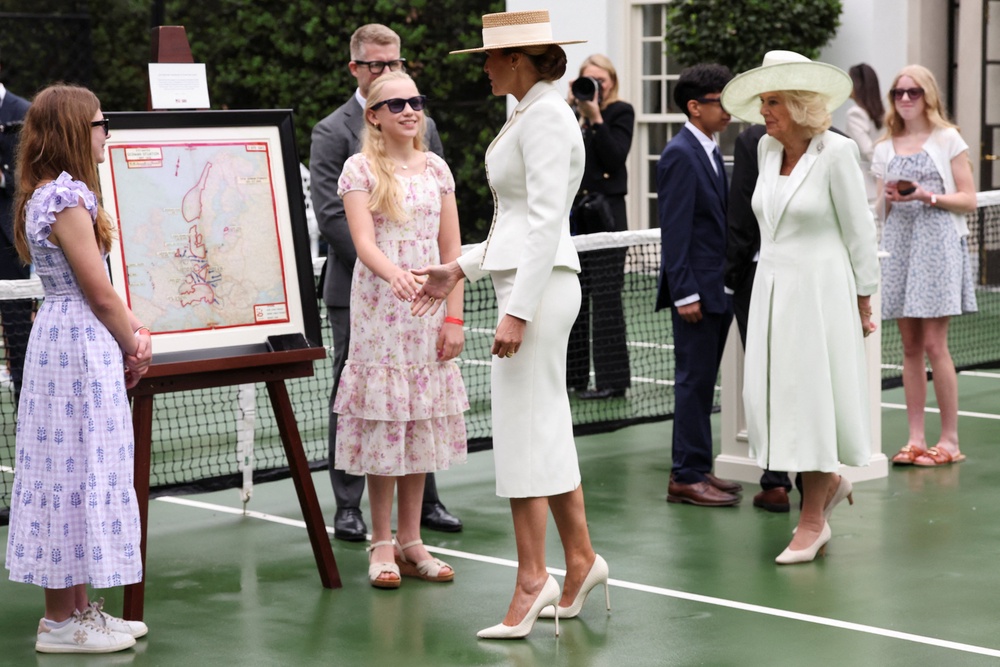 Queen Camilla and First Lady Melania Trump speak with students about the US-UK history on the White House tennis court (PA Wire)