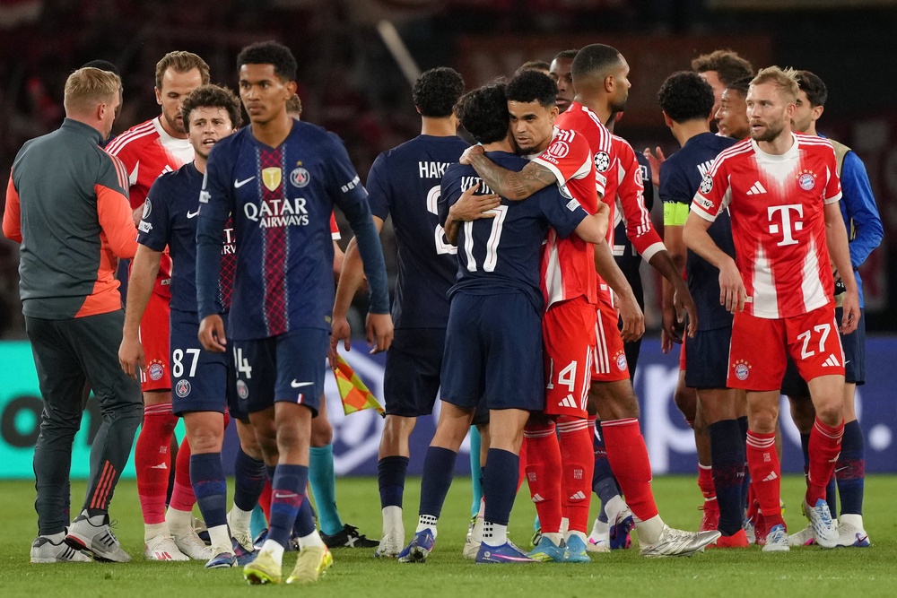 Bayern’s Luis Diaz, centre right, and PSG’s Vitinha embrace after a Champions League nine-goal semi-final thriller (Aurelien Morissard/AP) (AP)