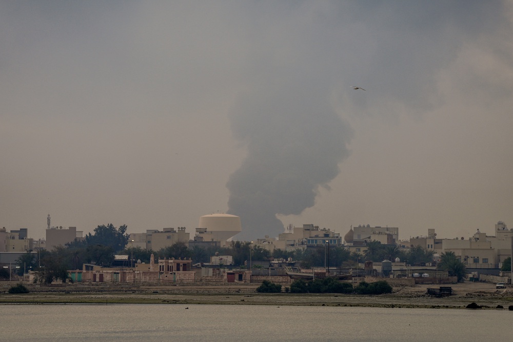 A plume of smoke rises after a reported Iranian strike on fuel tanks in Muharraq in Bahrain on 12 March 2026 (AFP/Getty)