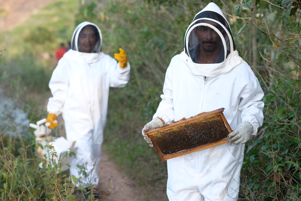 Maria Ramirez and Jose Garcia with honey from their beehives in Honduras. The beehive was installed with support from Christian Aid as a drought-proof means of generating income, as their region faces ever more unpredictable weather (Amy Sheppey/Christian Aid)