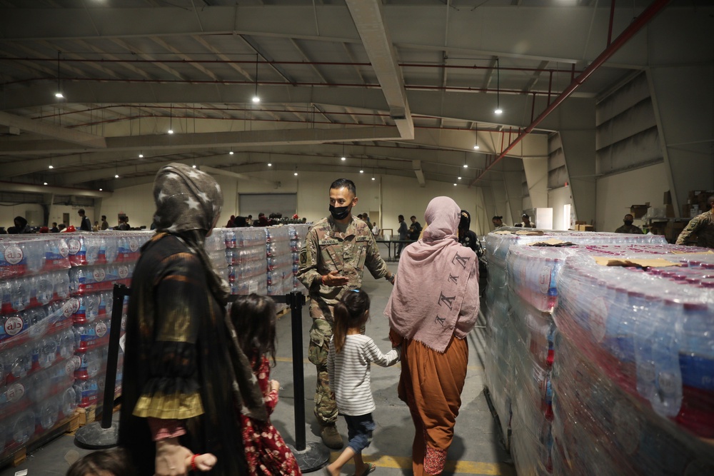US soldier files in Afghan Special Immigrants into the dining facility at Camp As Sayliyah in Qatar (Getty)
