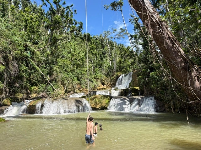 Enjoying the rope swing at the beautiful YS Falls, which reopened three months after the hurricane (The Independent)