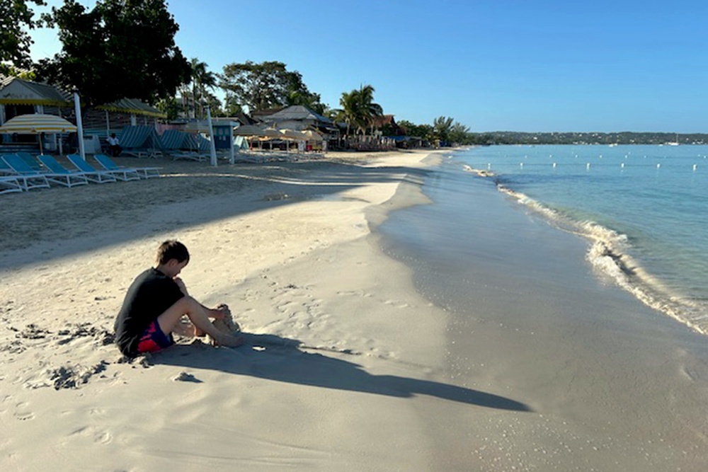 Playing in the sand on Negril beach in the early morning (The Independent)