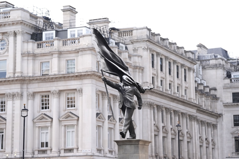 A statue of a man holding a flag which covers their face, and signed ‘Banksy’, has appeared in Waterloo Place in central London (Stefan Rousseau/PA) (PA Wire)