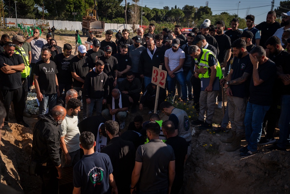 Mourners gather during a funeral at a makeshift cemetery for Hussein Ghadbouni, one of three members of the Lebanese Civil Defense who were killed in an Israeli airstrike on Tuesday (Getty)