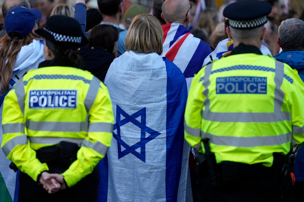 Police officers stand on dury in crowd where woman wears Israeli flag (AFP/Getty)