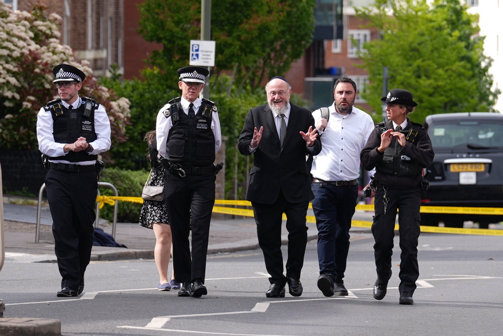Metropolitan Police Commissioner Sir Mark Rowley (second left) and Chief Rabbi Sir Ephraim Mirvis (third right) at the scene in Golders Green (Lucy North/PA) (PA Wire)