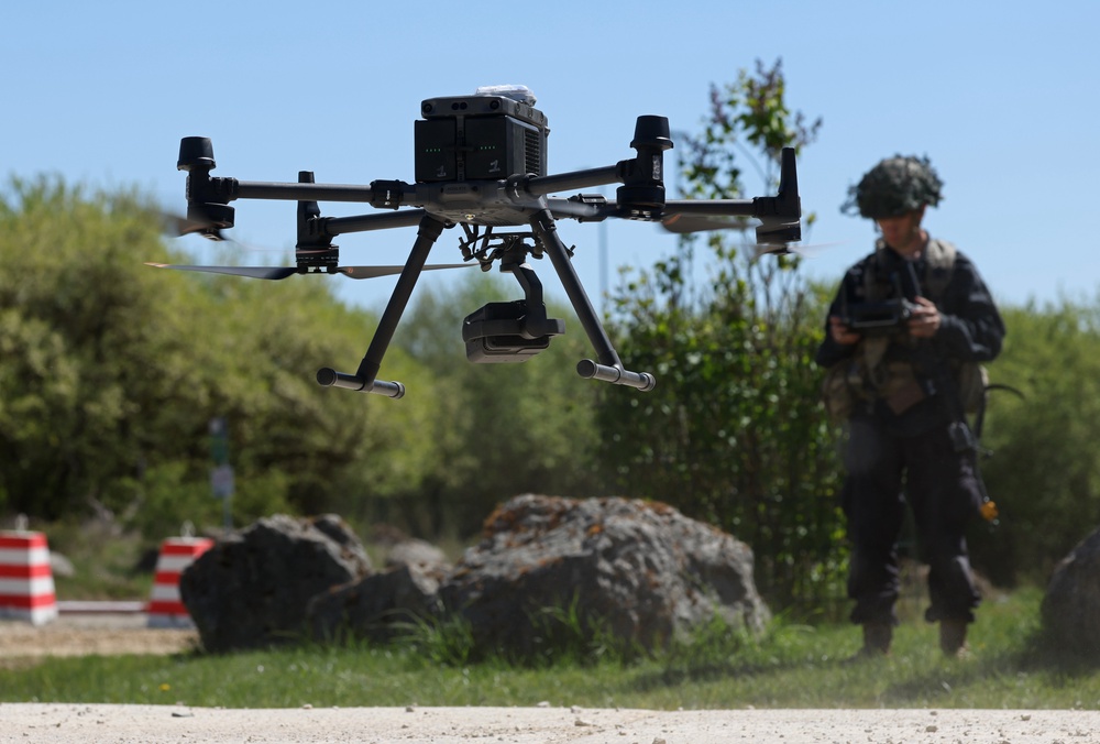 A member of the U.S. Army 7th Army Training Command, clad in black in the role of opposition force, pilots a DJI Matrice drone during the