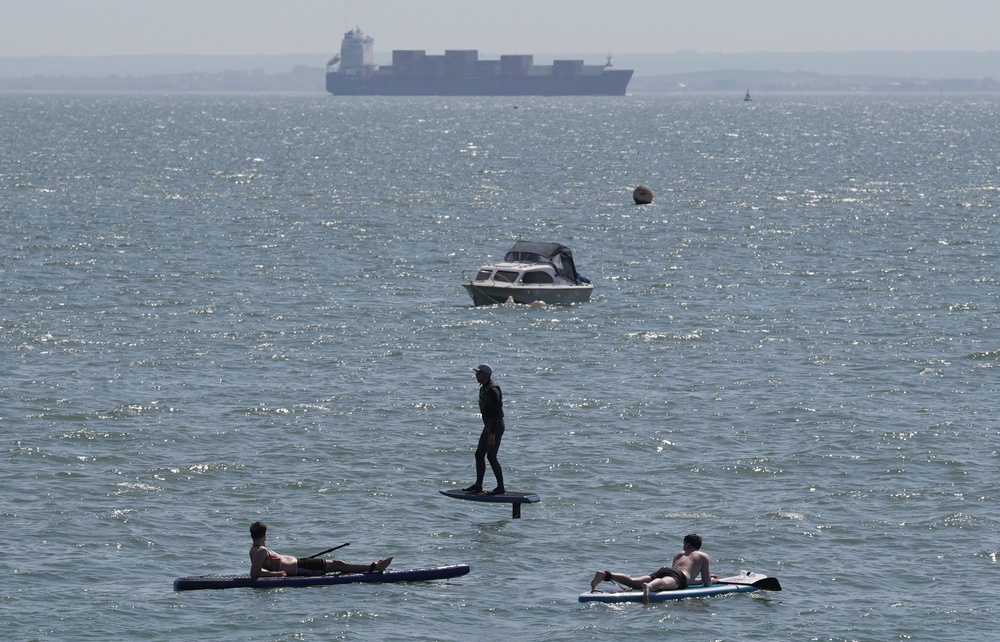 Paddleboarders watch as a person uses a hydrofoil during hot weather in Southend-on-Sea (Stefan Rousseau/PA) (PA Wire)