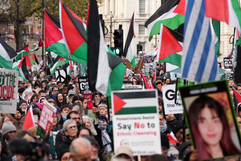 Protesters hold placards and wave Palestinian flags during a march organised by the Palestine Solidarity Campaign in central London on November 29, 2025, calling to ‘end the occupation, end apartheid and stop arming Israel’ (AFP/Getty)