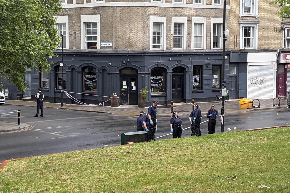 Police searching near the scene in Brixton after four people were taken to hospital with gunshot wounds (Clara Margotin/PA) (PA Wire)