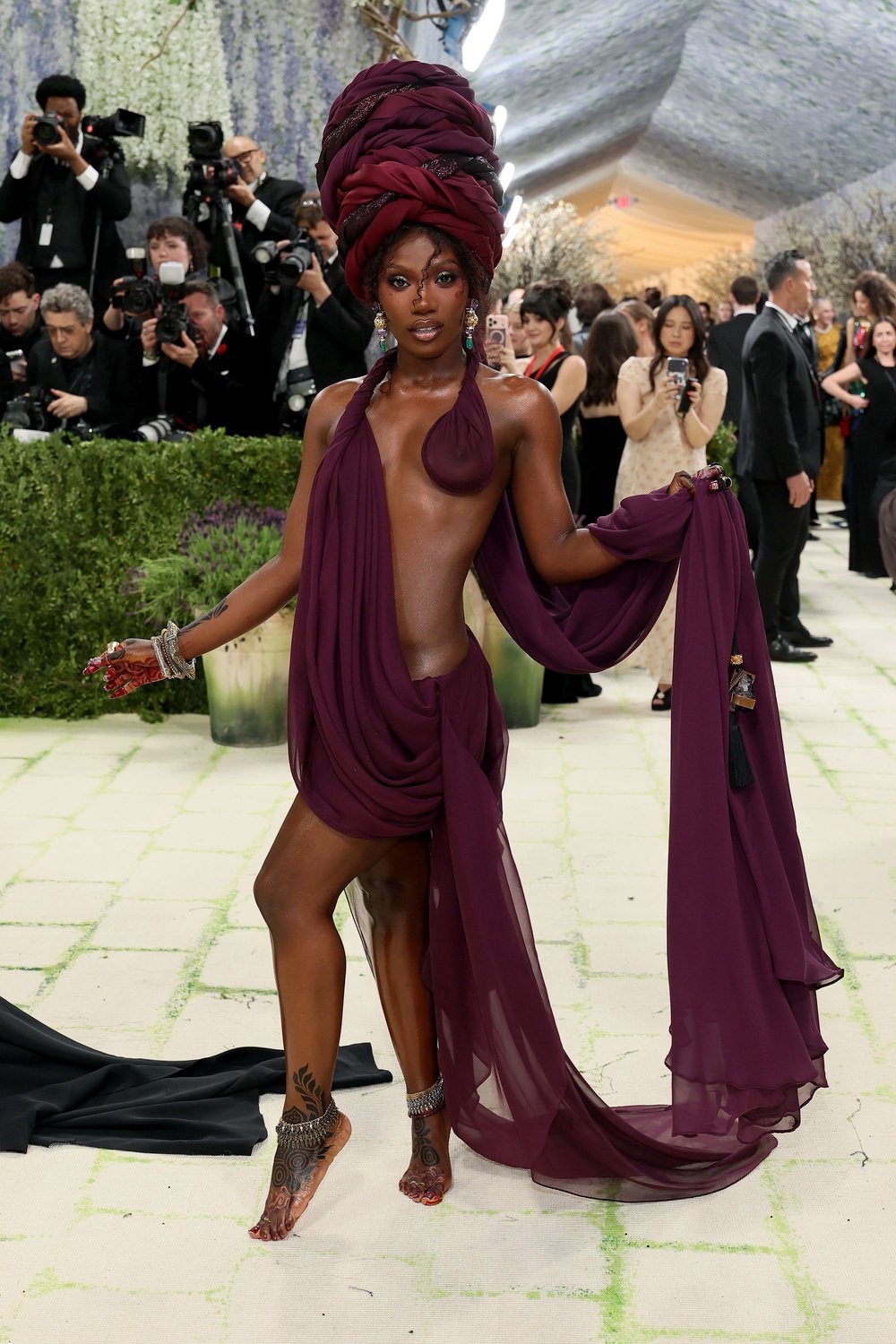 The rapper stole the show in a burgundy draped gown with cut-out detailing, worn with bare feet (Getty)