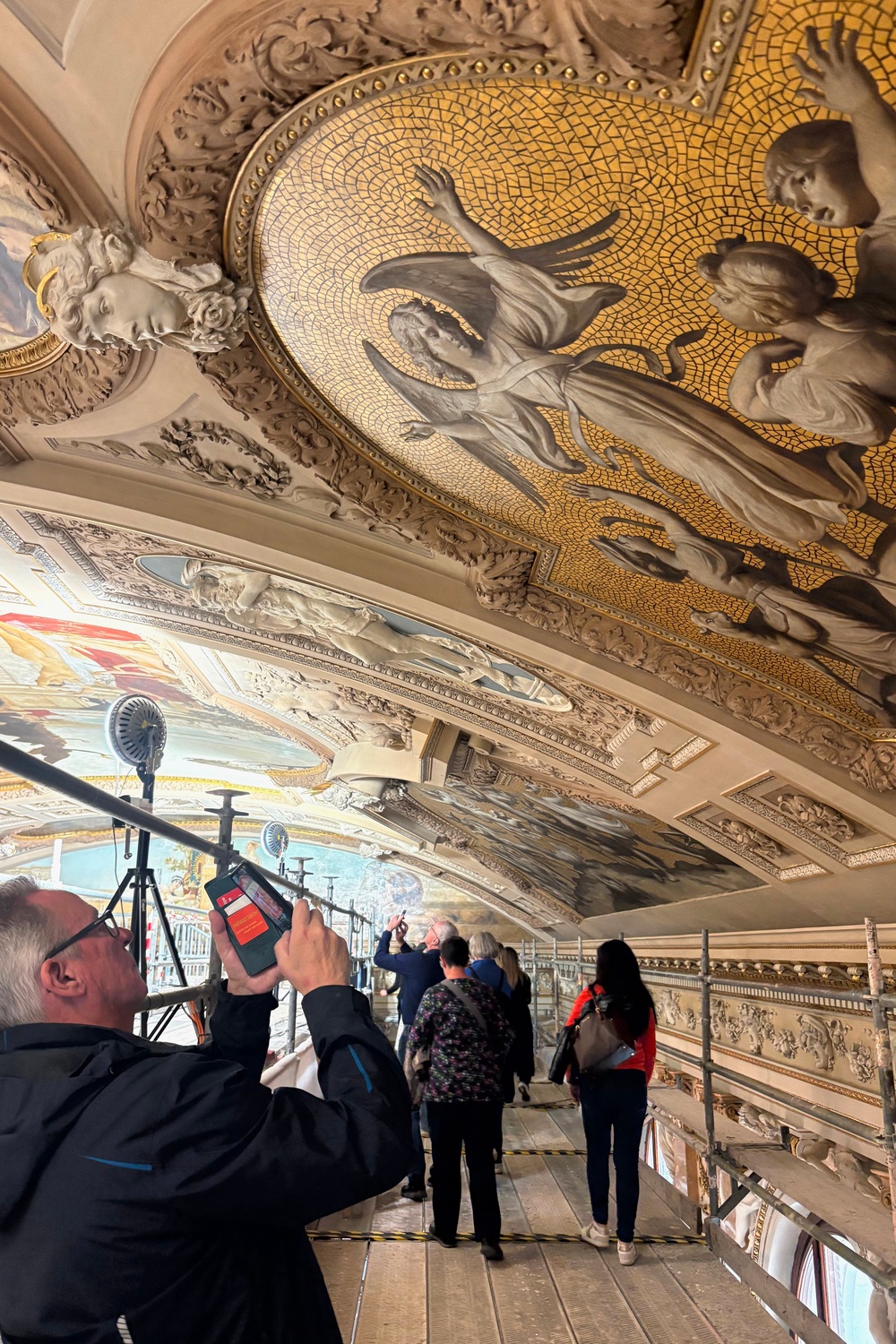A man takes a picture with his mobile phone during a guided tour of the restoration of Gustav Klimt's ceiling paintings at the Burgtheater (AP Photo/Philipp-Moritz Jenne)