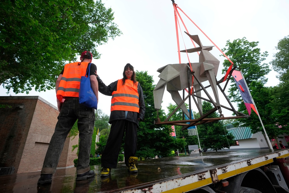 Ukrainian artist Zhanna Kadyrova poses flanked by Ukrainian artist Nikita Kravtsov next to her installation 'The Origami Deer' (AP)