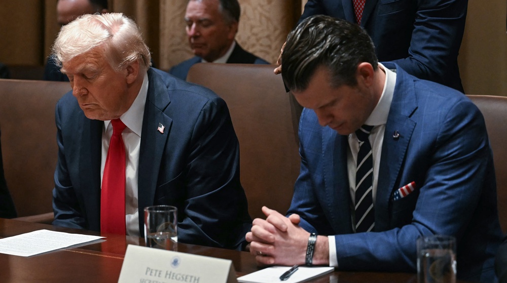 Hegseth prays next to President Donald Trump during a Cabinet meeting in the White House on Feb. 26, 2025, in Washington (AFP/Getty)