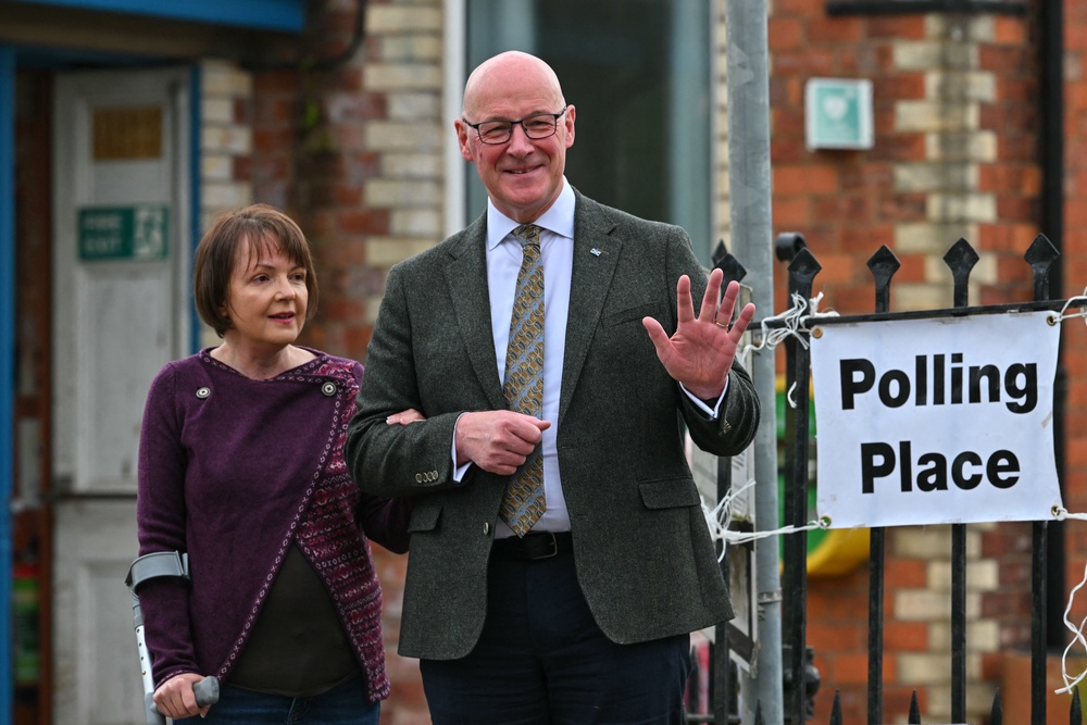 SNP leader John Swinney (R) waves with wife Elizabeth (L) outside a polling station in Burrelton, Perthshire (AFP/Getty)