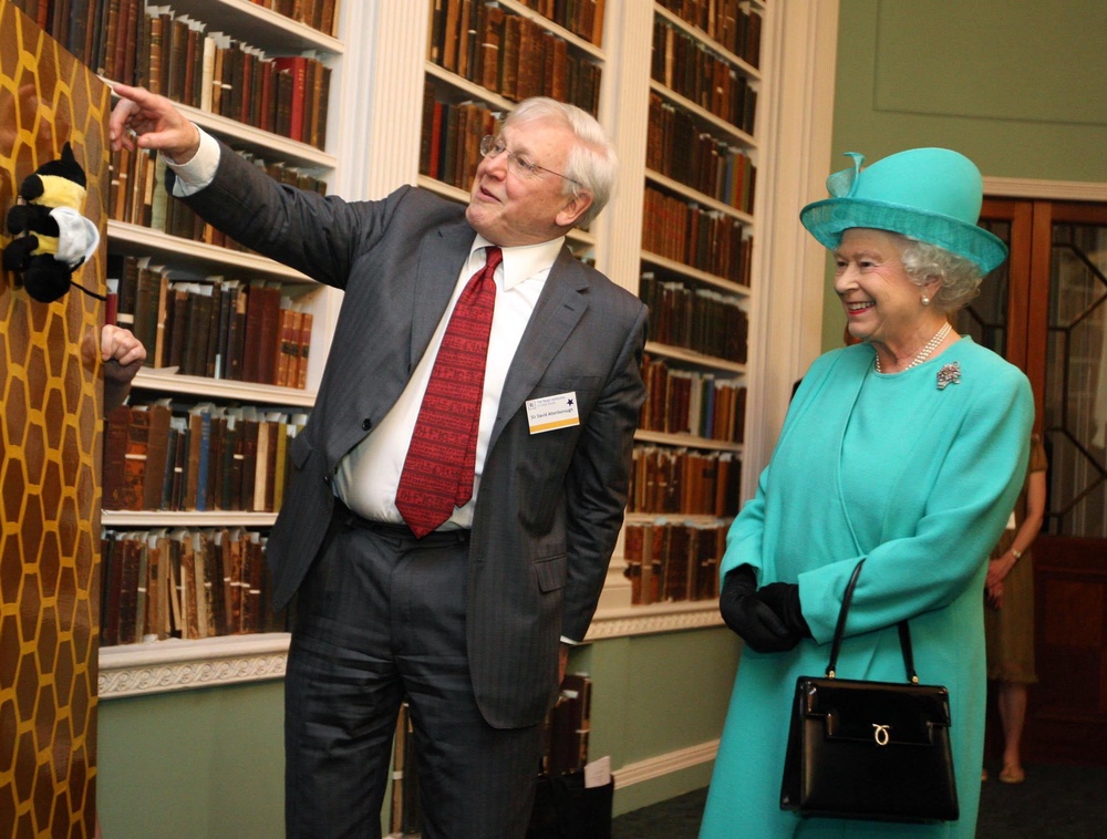 Queen Elizabeth II smiling as Sir David Attenborough gives a segment of a Christmas Lecture at the Royal Institution of Great Britain. (PA)