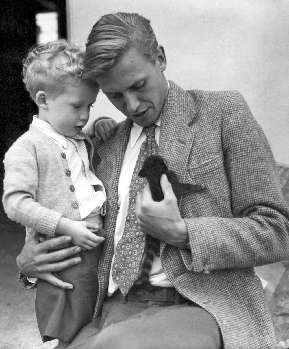 David Attenborough holding his son Robert whilst looking at an animal called a coati-mundi, brought home from the combined London Zoo - BBC expedition to British Guyana. (PA)