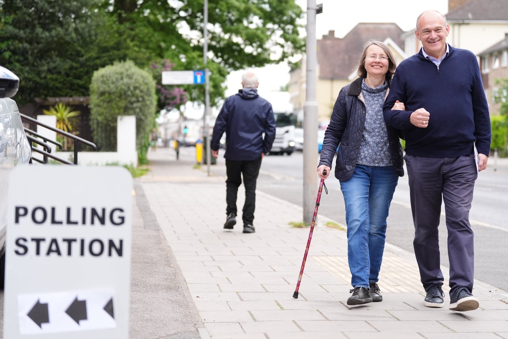 Liberal Democrat leader Sir Ed Davey and his wife Emily Davey arrive to cast their votes in Surbiton (PA)