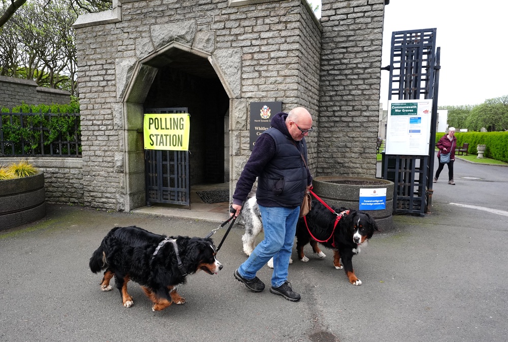 A voter leaves with his dogs after casting a vote in the 2026 local elections at Whitley Bay Cemetery (Owen Humphreys/PA) (PA Wire)