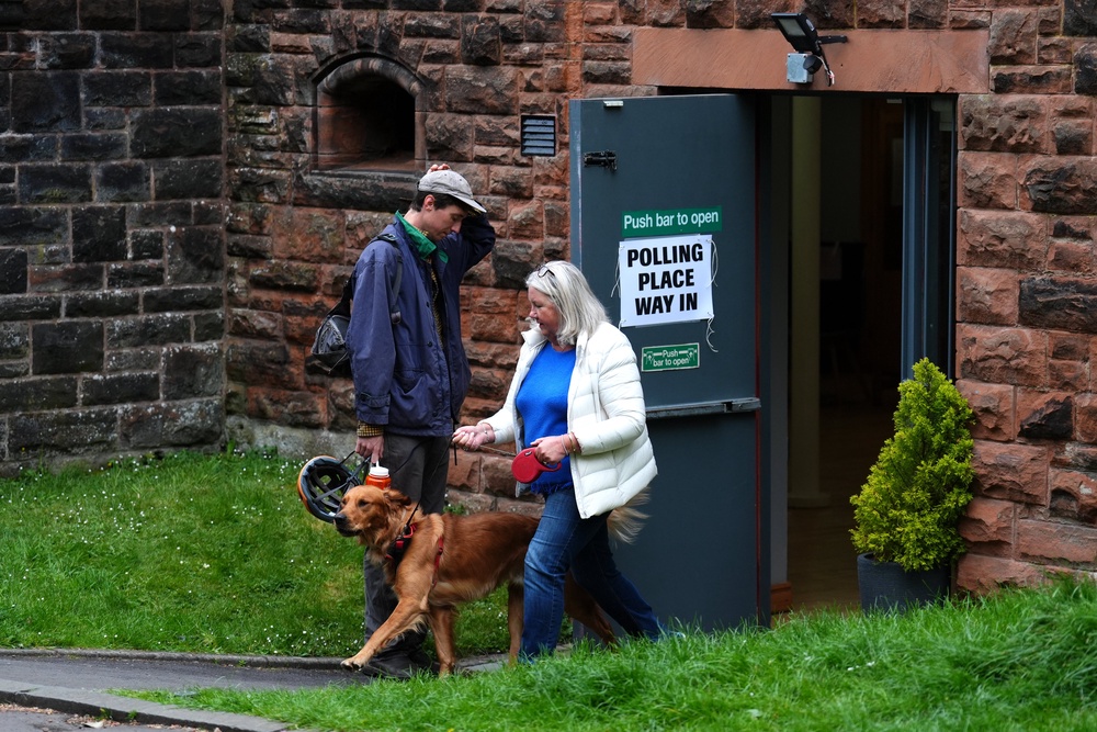 A voter and their dog at Pollokshields Burgh Hall, Glasgow (Andrew Milligan/PA) (PA Wire)
