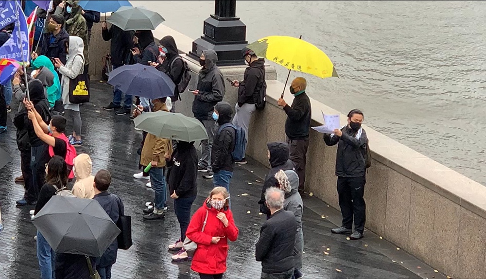 A pro-democracy protester holding a symbolic yellow umbrella in London (PA)
