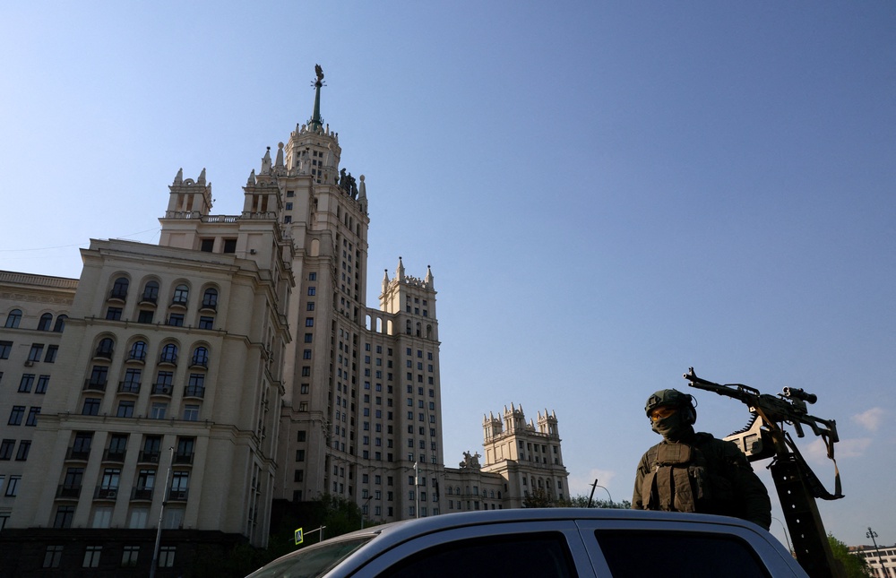 A security guard stands atop a pickup truck armed with a machine gun while patrolling an area in central Moscow (Reuters)